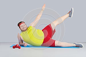 Fat funny man with a beard doing exercises goes in for sports.