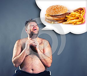 Fat funny man dreaming about hamburger