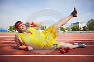 Fat funny man lying on the phone talking on the track