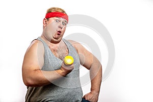 Fat funny man in red headband shows his muscles with dummbell and emotions