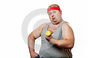 Fat funny man in red headband shows his muscles with dummbell and emotions