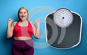 Fat girl does gym at home with satisfied expression because she decrease her weight. purple background