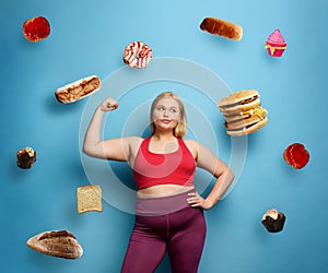 Fat girl does gym at home. thoughtful expression. Cyan background
