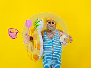 Fat happy man with wig in head is ready to swim with a donut lifesaver