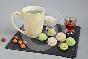 Fat keto peanut butter, cheesecake, matcha balls and keto matcha coconut bulletproof tea in yellow cup. keto protein balls and