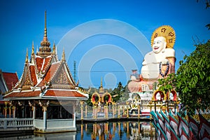 Fat laughing Buddha over blue sky, Koh Samui