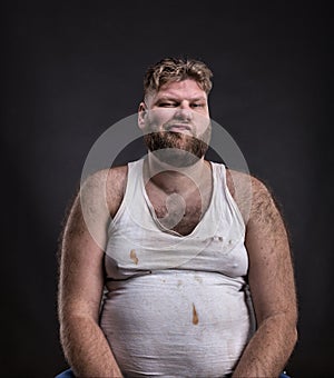 Fat man with beard in dirty shirt photo