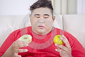 Fat man confused between prefer doughnut or apple