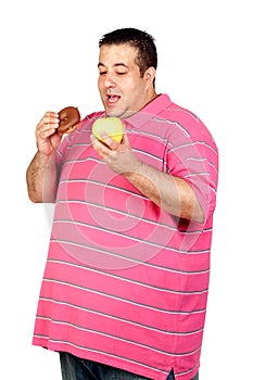 Fat man deciding between a candy and an apple