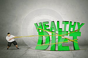 Fat man drags healthy diet text with a measure tape