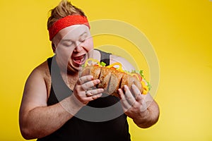 Fat man eating fast food hamberger