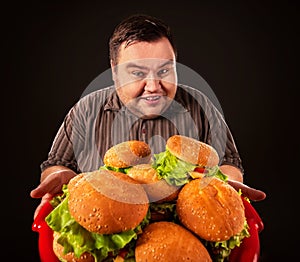 Fat man eating fast food hamberger. Breakfast for overweight person.