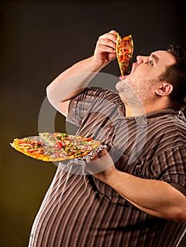 Fat man eating fast food slice pizza . Breakfast for overweight person.