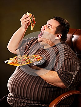 Fat man eating fast food slice pizza. Breakfast for overweight person.