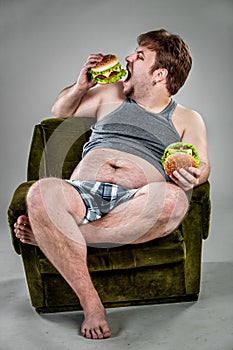 Fat man eating hamburger