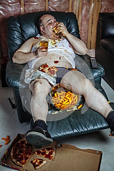 Fat man eating and watching television photo