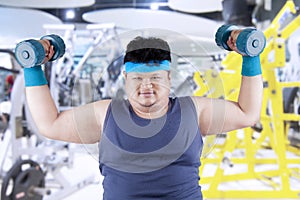 Fat man exercise in fitness center 1
