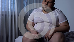 Fat man feels heaviness and pain in stomach, abdominal bloating, indigestion photo