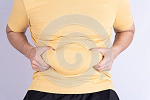 Fat man holding excessive fat belly isolated grey background