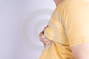 Fat man holding excessive fat boobs isolated grey background