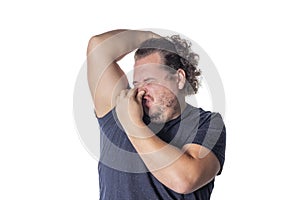 Fat man holds or pinches his nose shut because of a stinky smell or odor photo