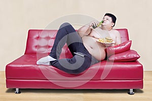 Fat man leaning on the couch