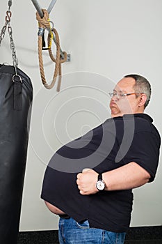 Fat man match belly with a punching bag