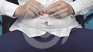 Fat man office worker buttoning a shirt on a fat stomach with wrinkles, excess weight, obesity, unhealthy diet, close-up