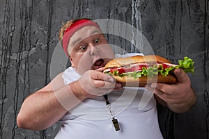 Fat man opened his mouth to bite off a tidbit of a sandwich