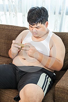 Fat man play game with his smartphone