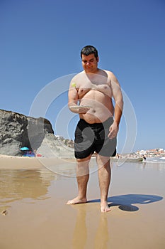 Fat man playing beach tennis on the beach