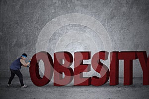 Fat man pushing an obesity word photo