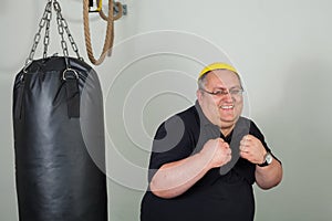 Fat man struggling with a punching bag