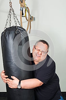 Fat man struggling with a punching bag