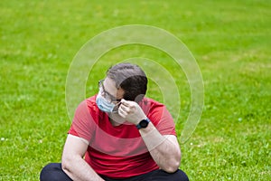 Fat man taking off face mask to inhale some fresh air