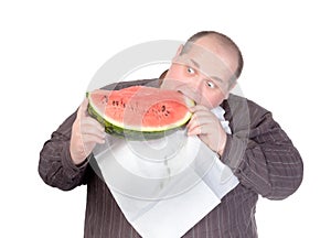 Fat man tucking into watermelon