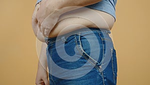 The fat man zips the zipper on the jeans. weight problems, diet, overweight, obesity