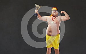 Fat naked man with a champion`s cup in his hands.