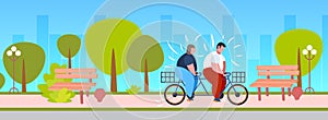 Fat obese couple riding tandem bicycle overweight man woman cycling twin bike weight loss concept summer park landscape