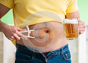 Fat obese man holding beer in dieting concept