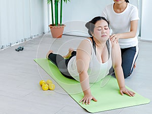 Fat overweight woman learnt yoga on the mat from the femal yoga instructor