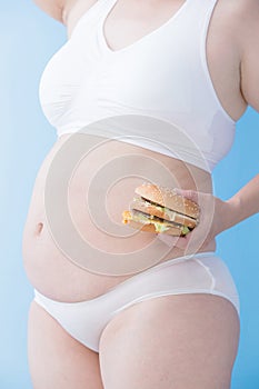 Fat overweight woman take hamburger