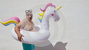 Fat ridiculous man with an unicorn float