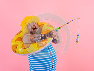 Fat stressed man with wig in head plays with the fishing rod