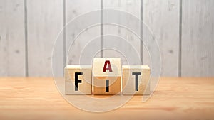 Fat versus Fit concept with words on wooden blocks with revolving letter depicting options, choices and a healthy or unhealthy