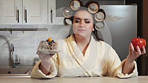 Fat Woman choosing healthy or unhealthy food. A girl making a choice between an apple and a piece of cake chooses a cake