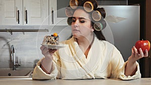 Fat Woman choosing healthy or unhealthy food. A girl making a choice between an apple and a piece of cake chooses a cake