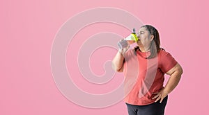 Fat woman dinking a water or supplement bottle,