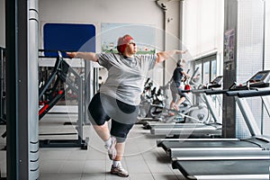 Fat woman doing balance exercise in gym