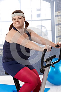 Fat woman on exercise bike